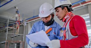 Two Men Holding White Paper