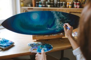 A Parson Painting the Sea Waves on the Surfboard