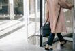 Anonymous businesswoman leaving through revolving door