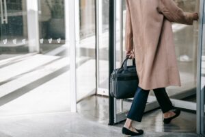 Anonymous businesswoman leaving through revolving door