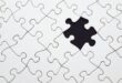 Close-up of an incomplete white puzzle with one missing piece, symbolizing challenge and strategy.