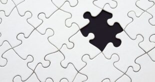 Close-up of an incomplete white puzzle with one missing piece, symbolizing challenge and strategy.