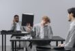 Coworkers in an office dealing with stress and paperwork fatigue.