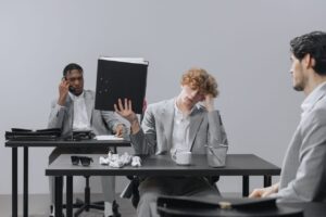 Coworkers in an office dealing with stress and paperwork fatigue.