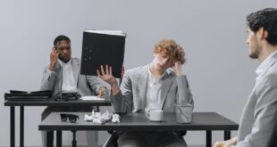 Coworkers in an office dealing with stress and paperwork fatigue.