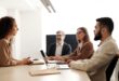 Business team meeting with diverse members collaborating in a modern office.