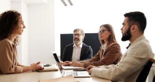 Business team meeting with diverse members collaborating in a modern office.