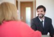 Professional businessman smiling and handshaking during a meeting in an office setting.