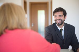 Professional businessman smiling and handshaking during a meeting in an office setting.