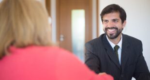 Professional businessman smiling and handshaking during a meeting in an office setting.