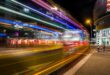 Dynamic city street at night captured with vibrant light trails from long exposure photography.