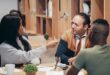 A diverse group of professionals discussing ideas in a collaborative workspace.