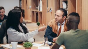 A diverse group of professionals discussing ideas in a collaborative workspace.