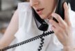 Close-up of a woman talking on a phone in an office setting.