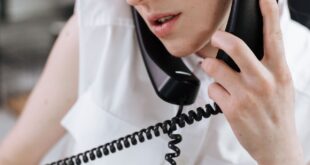 Close-up of a woman talking on a phone in an office setting.